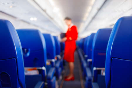 Passenger seat in airplane, Interior of airplane and stewardess background. Stewardess renders services for passengers. Service concept, travel concept.の写真素材