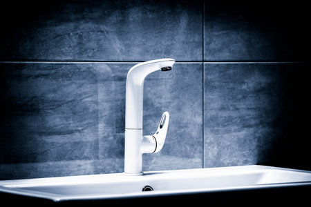 Luxury modern style white faucet mixer on a white sink in beautiful dark blue bathroomの写真素材