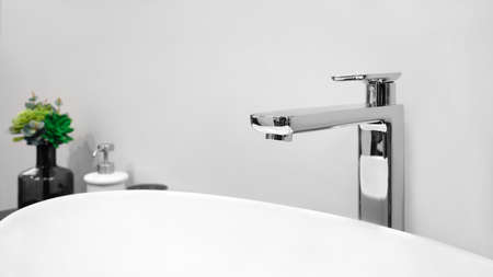 Luxury modern style faucet mixer on a white sink in a beautiful gray and white bathroomの写真素材
