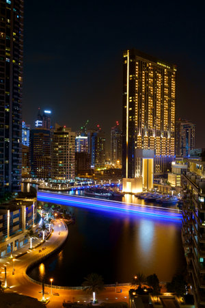 Night river traffic long tracers in Dubai UAE center along a city river with colorful reflections and blurred smokのeditorial素材