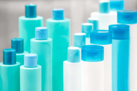 Several different close up of a white and turquoise blue designer plastic bottle for cosmetics and perfumery or for other liquidsの写真素材