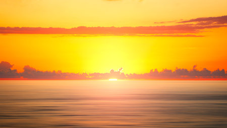Abstract sunrise background of sea and cloudy sky over it. Motion blur sea water and red sky with...