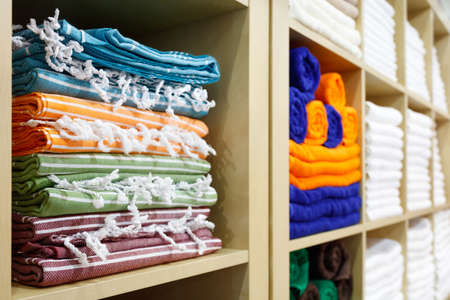 Fresh White and colorful Hotel Towels Folded and Stacked on a Shelfの写真素材
