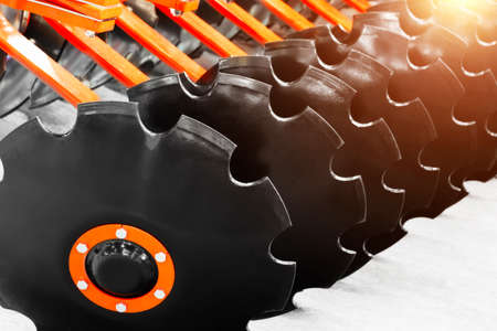 Working parts of new modern agricultural disc harrow. Tillage equipment. Close-up view of cultivating discs, selective focusの写真素材