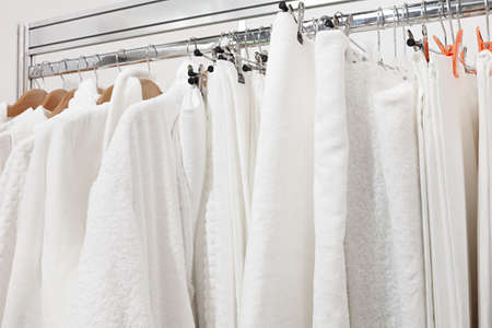 White bathrobe with hanger and towel in wardrobe at hotel room.Close up of clothes hanger and bathrobe in wardrobe in hotel.の写真素材