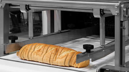 Sliced white bread in a cutting machineの写真素材