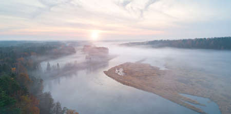 Summer autumn warm sun light forest and foggy river aerial viewの写真素材