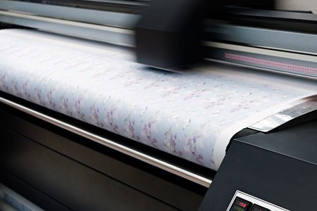 Industrial printing on woven material; modern digital inkjet printer puts a blue pattern picture on...