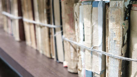 close-up old books tied with a rope on wooden shelf  in the Library or in the archiveの写真素材
