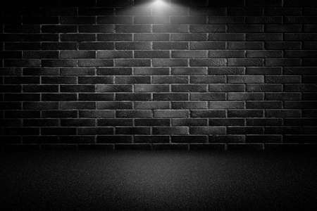 Highly contrasted spotlights on an outdoor black brick wallの写真素材