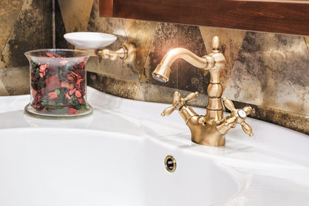 Retro golden faucet in the bathroom
