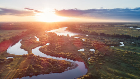 Aerial view of beautiful small island with green trees and boats on the river at sunset in summer....
