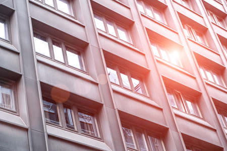 Modern  facade of a building with windows reflecting the sun and skyの写真素材