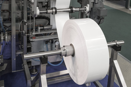 Fragment of the conveyor of sticking labeling machine. Abstract industrial background.