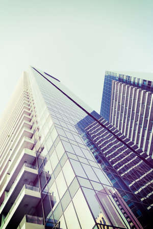 Abstract skyscrapers with sun glare toned in vintage style