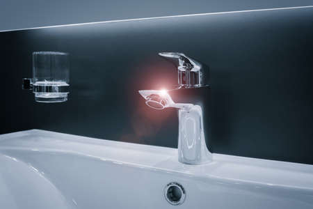 Hygiene concept. Luxury modern style faucet on a white sink in a beautiful bathroomの写真素材