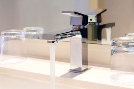 Luxury modern style faucet on a white sink in a beautiful bathroomの写真素材