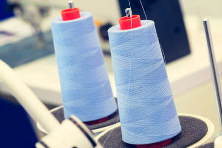Reels of textile yarn blue thread at industrial weaving manufacturing machineの写真素材