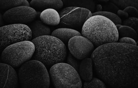Dark black abstract smooth round pebbles sea texture backgroundの写真素材
