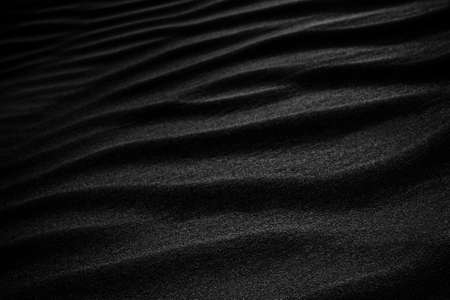 Black Sand dune. Black Sand beach macro photography. Background, texture, wave pattern of oceanic sand on the beach, black. Texture of beach sand. Black beach.の写真素材