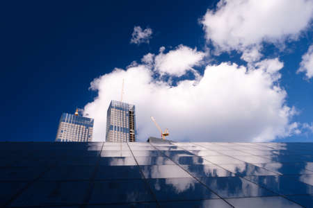 Skyscraper glass facades on a bright sunny day with sunbeams in the blue sky. Economy, finances, business activity concept. Bottom up viewの写真素材