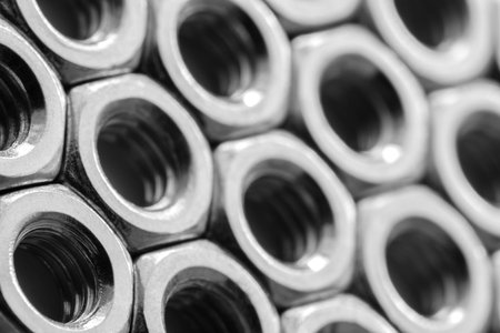 Metal nuts in a row background. Chromed screw nuts. Steel nuts pattern. Tools for work.の写真素材