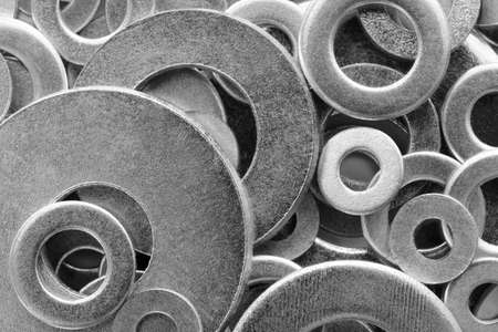 Abstract industrial textured metal background with many metal washers for bolts and screws close-upの写真素材
