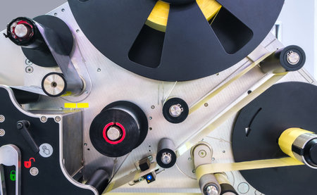 Fragment of the conveyor of sticking labeling machine. Abstract industrial background.