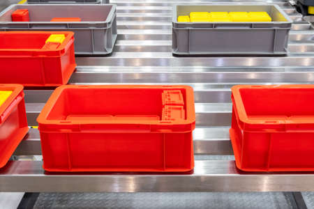 Plastic red box on roller line for tranfer production part in prodine lin in factory, production, transportation conceptの写真素材