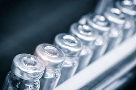 Glass bottles in production in the tray of an automatic liquid dispenser, a line for filling medicines against bacteria and viruses, antibiotics and vaccines.の写真素材
