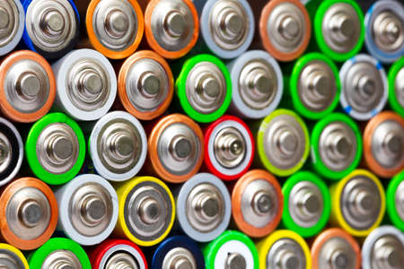 Closeup of pile of used alkaline batteries. Close up colorful rows of selection of AA batteries energy abstract background of colorful batteries. Alkaline battery aa size. Several batteries in rows.の写真素材