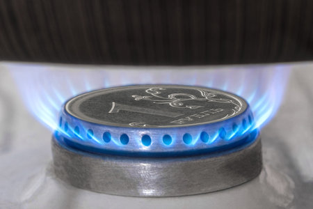 Gas burner and ruble coin, Russian money on home gas stove. Blue propane gas flame and ruble...