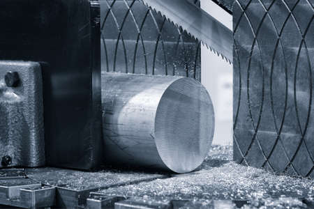 Automatic saw bandsaw sawing metal workpiece, industrial concept backgroundの写真素材