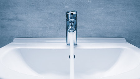 bathroom water faucet. Water tap made of chrome material, Faucet with water in blue toneの写真素材
