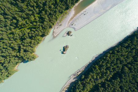 Drone aerial top view of mountain river and forest, Lonely island in a flowing swift turquoise water...