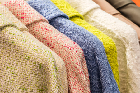 Fashion clothes on clothing rack - bright colorful closet. Closeup of rainbow color choice of trendy...