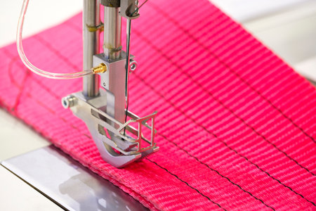 Professional sewing machine and sews red garmentsの写真素材