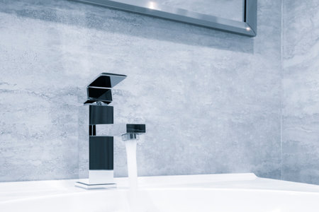 Faucet and water drop close up. Bathroom interior with sink and water tap. Flow water in bathroom with sink.の写真素材