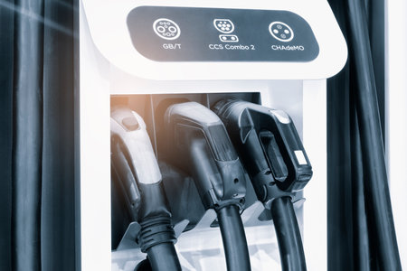 Blurred electric car charging station for charge EV battery. Plug for vehicle with electric engine. EV charger. clean energy. Charging point at car parking lot. Future transport technology.の写真素材