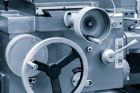 Lathe control knobs close up blue tone. metal machine tool industry. The metalworking process by...