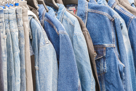 blue, black and brown jeans denim trousers and jackets in a clothing storeの写真素材