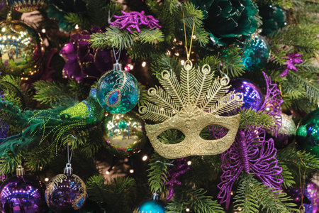 Close-up of gold colored mask shaped and christmas toys on the Christmas treeの写真素材