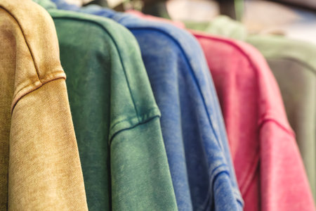 Fashion hoodie clothes on clothing rack Closeup of rainbow color choice female wear on hangers in a clothing store closet Summer home wardrobe.の写真素材