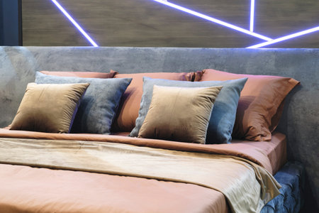 Interior of a modern bedroom in an apartment, hotel or private house with a bed and pillows