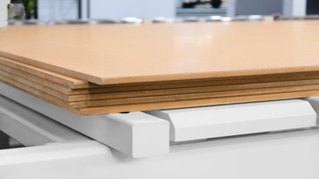 Wood boards on a woodworking machine in a modern furniture factory, woodworking industrial concept...
