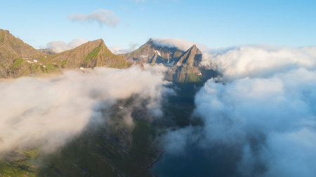 Landscape with mountain peaks in dawn clouds, vacation conceptの写真素材