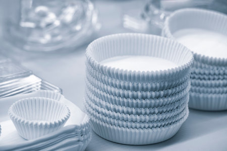 A stack of paper dishes with a blue background. The cups are white and are piled on top of each otherの写真素材