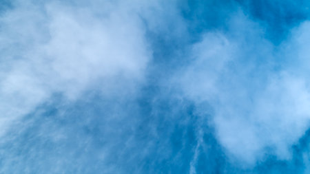 The sky is blue and cloudy. The clouds are white and fluffy. The sky is clear and brightの写真素材