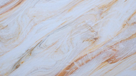 A white and brown stone wall with a pattern of swirls and lines. The wall is smooth and shiny,...