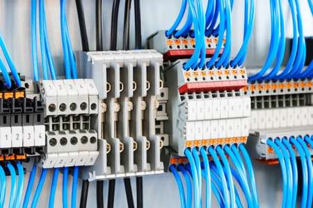A blue and white electrical cable with a number of different colored wires. The cables are connected to a box with a number of different colored wires coming out of itの写真素材